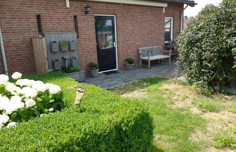 Ingang van Vakantiehuis in De Pollen, Vriezenveen, Twente, met verzorgde tuin en zitgelegenheid.
