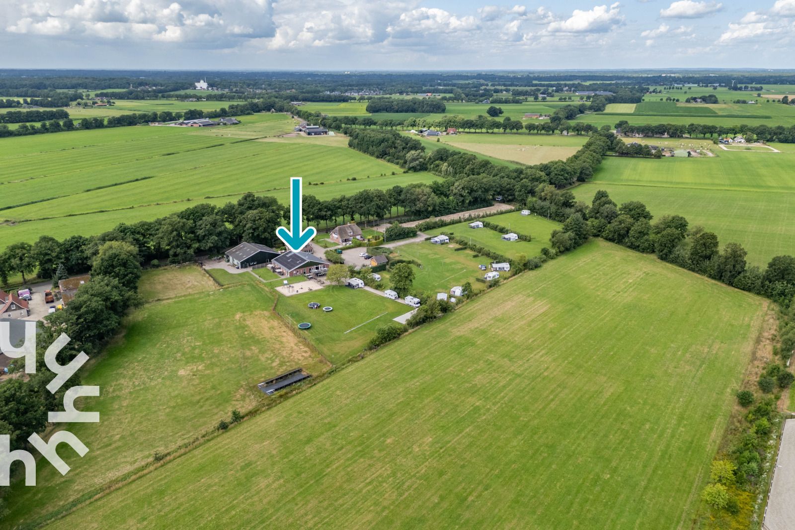 Bewaldetes Gebiet mit Holzstapeln am Ferienhaus OV243 in Luttenberg, Overijssel.