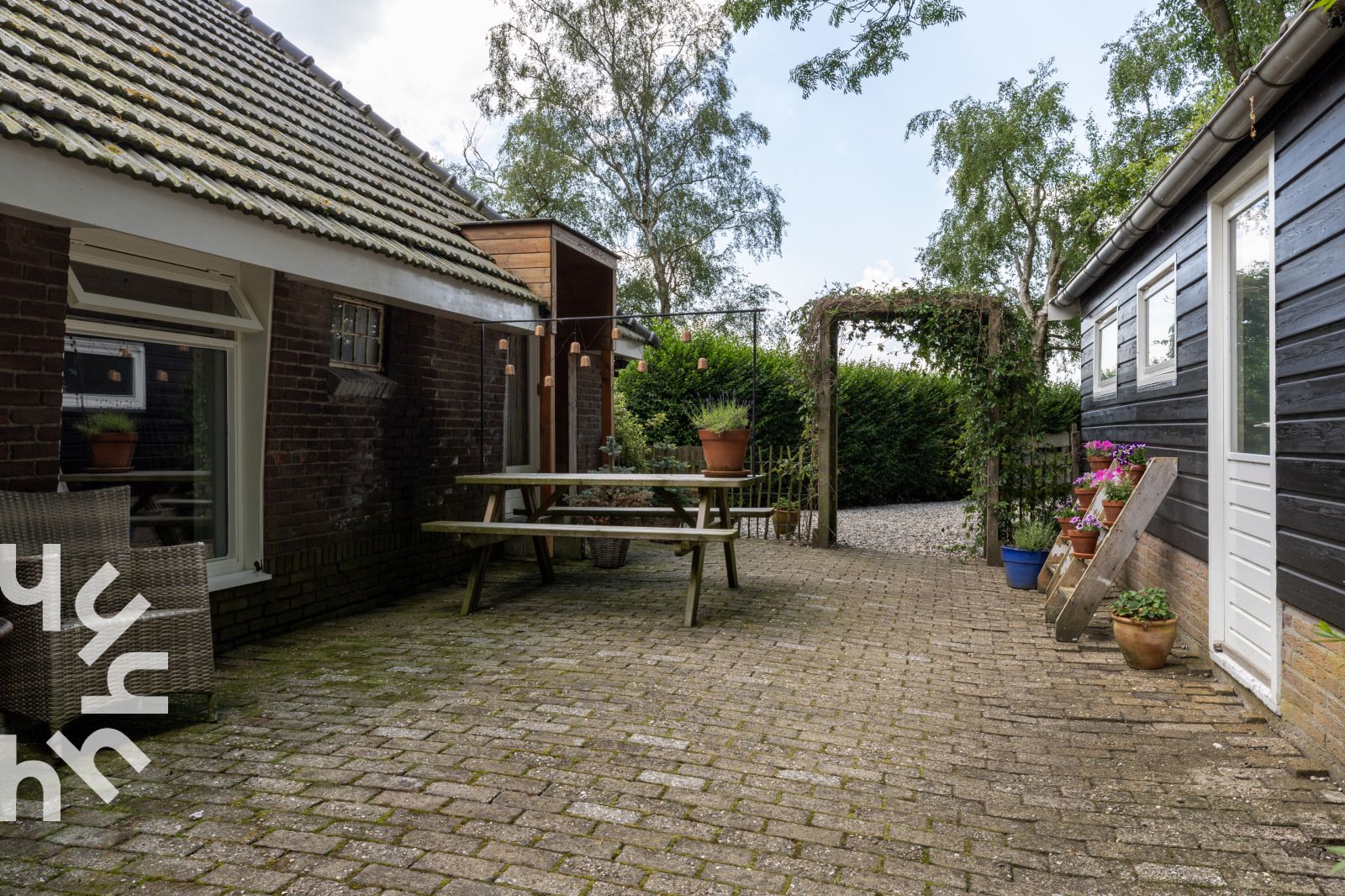 Ingang van OV529 vakantiehuis in Zwolle, Salland, met houten deur en planten.