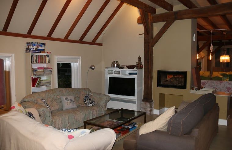 Cozy living room in cottage in Heeten, Overijssel, with comfortable sofas and fireplace.
