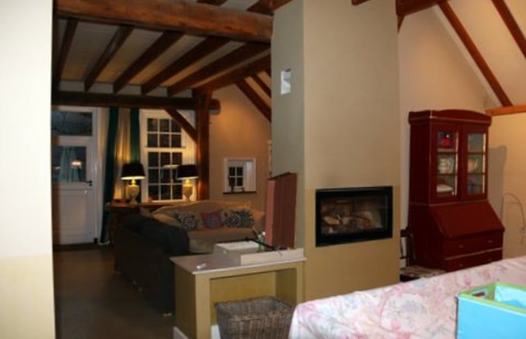 Spacious living room in cottage in Heeten, Salland, with wooden beams and cozy atmosphere.