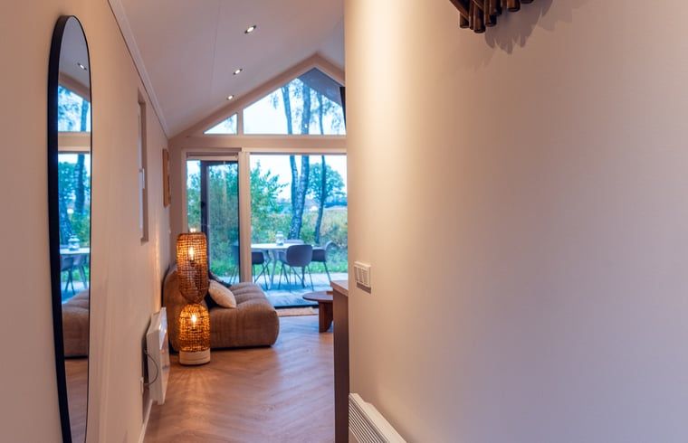 Lichte woonkamer met uitzicht op de natuur in Vakantiehuisje in Haarle, Overijssel.