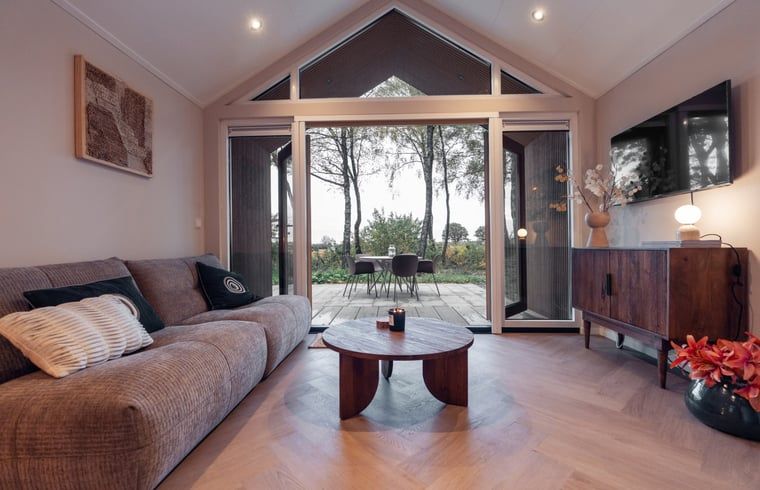 Woonkamer met uitzicht op de tuin in Vakantiehuisje in Haarle, een oase in Salland, Overijssel.