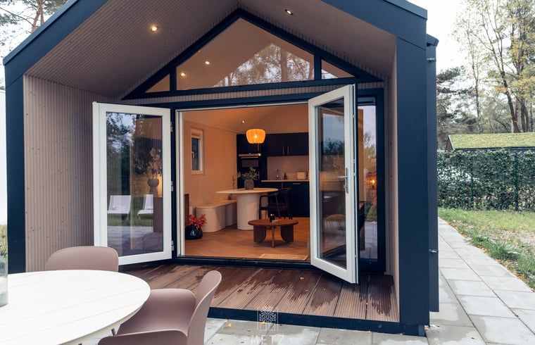 Buitenterras van Vakantiehuisje in Haarle met toegang tot de woonkamer, gelegen in het groene Overijssel.