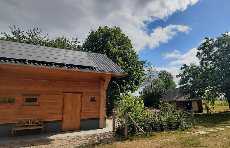 Sustainable Holiday Home in Wesepe, Overijssel with solar panels and rural garden.