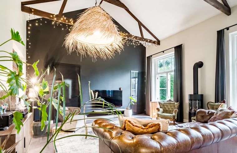 Gezellige binnenruimte in Vakantiehuis in Diepenveen, met sfeervolle verlichting en comfortabele zitplaatsen.