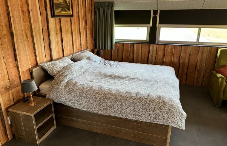 Slaapkamer in Vakantiehuisje in Boskamp, Salland, met tweepersoonsbed en houten interieur in Overijssel.