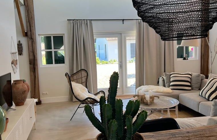 Gezellige woonkamer in Vakantiehuis in Ommen, Vechtstreek, Overijssel met modern interieur en uitzicht op de tuin.