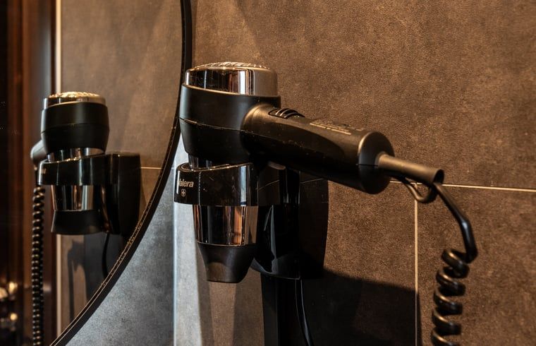 Fohn in de badkamer van Vakantiehuis in Ommen, een comfortabel verblijf in de Vechtstreek, Overijssel.