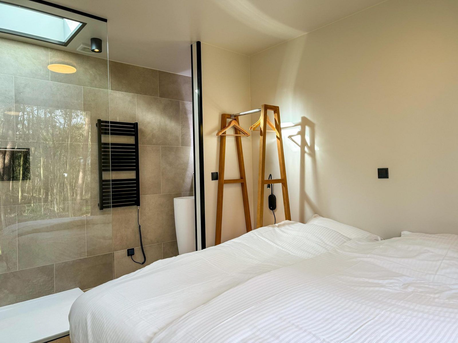 Schlafzimmer in der Hill Lodge Glamping Lodge, Beerze, mit luxurioesem Bett und angrenzendem Badezimmer.