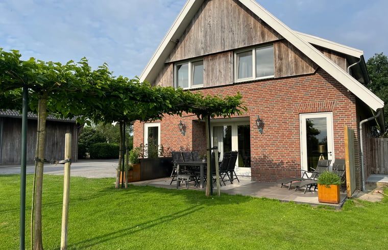 Aussenansicht des Ferienhauses in Beerze, ein charmantes Ferienhaus in der Region Vecht, Overijssel mit gruenem Garten und Terrasse.