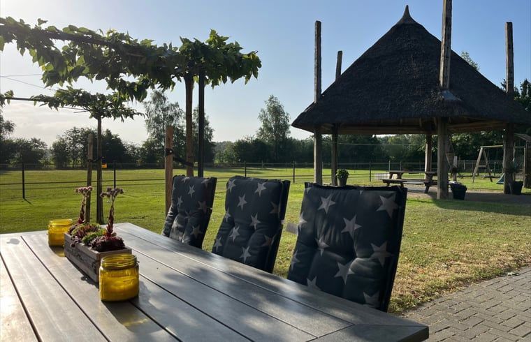 Sonnige Terrasse des Ferienhauses in Beerze, Region Vecht, Overijssel, mit Blick auf die laendliche Umgebung und den Pavillon.