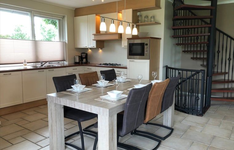Esszimmer und Kueche im Ferienhaus in Beerze, Vechtstreek, Overijssel mit moderner Einrichtung und offenem Treppenhaus.