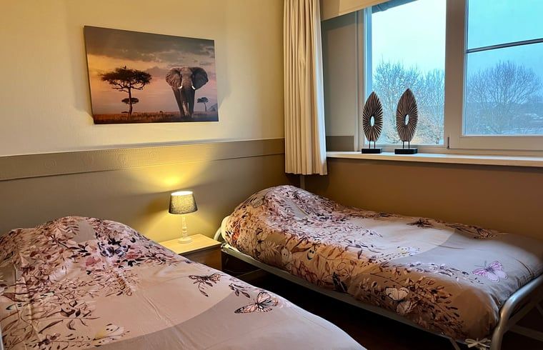 Schlafzimmer mit zwei Einzelbetten im Ferienhaus in Beerze, Vechtstreek, Overijssel mit Blick auf den Garten.
