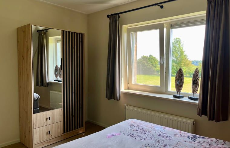 Schlafzimmer mit grossem Kleiderschrank in Ferienhaus in Beerze, Vechtstreek, Overijssel mit Blick auf die Natur.