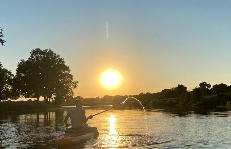 Kajakfahren auf dem Fluss bei Sonnenuntergang in der Naehe des Ferienhauses in Beerze, Region Vechta