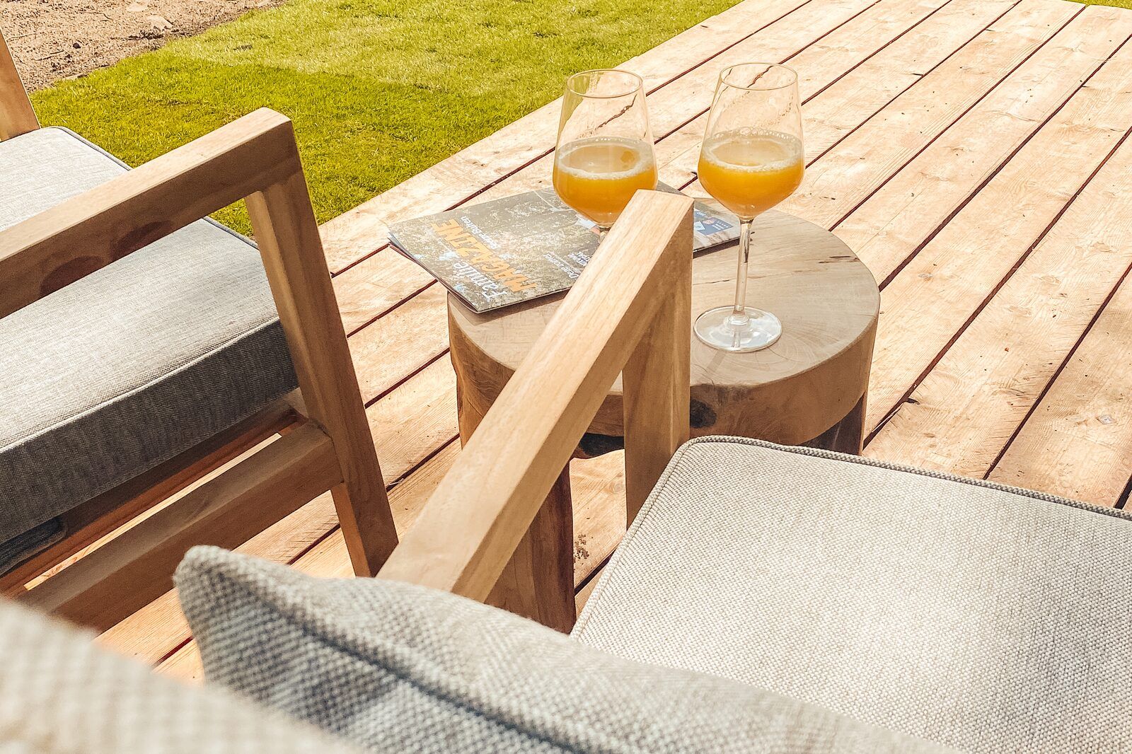 Relaxed terrace of Wikkelhouse vacation home in Beerze with drinks and magazines.