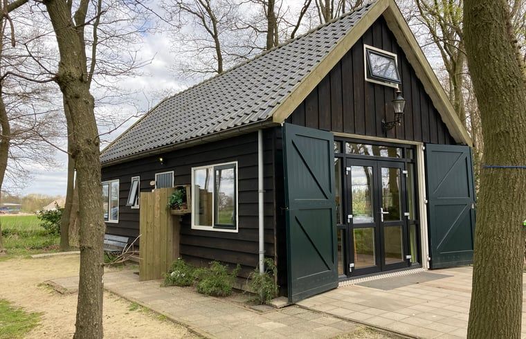 Vacation cottage in Dalfsen with rural feel, located in the Vecht region, Overijssel, surrounded by trees and nature.