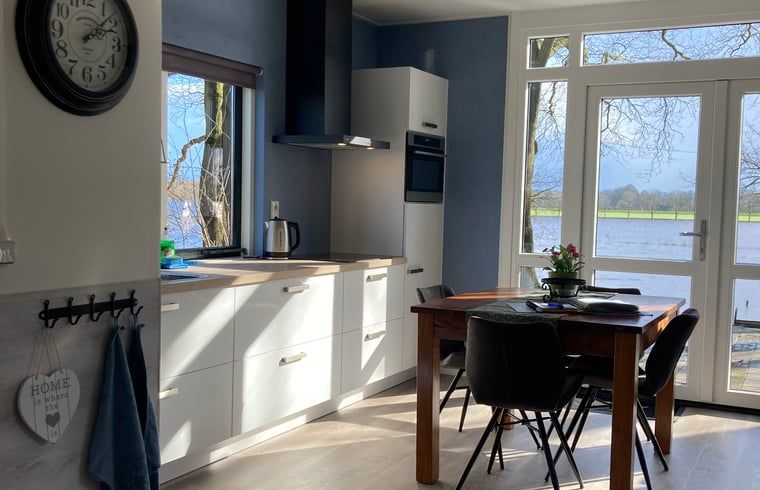 Dining area in Holiday Home in Dalfsen, Overijssel, with large window overlooking the Vecht region and the water.
