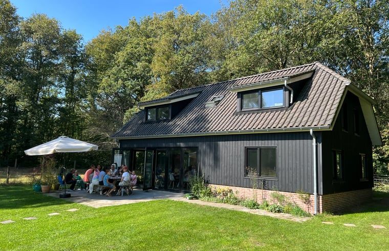 Gezellige groep op terras van Huisje in Balkbrug in Overijsselse natuur