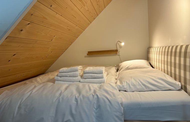 Comfortabel bed met handdoeken in Huisje in Balkbrug
