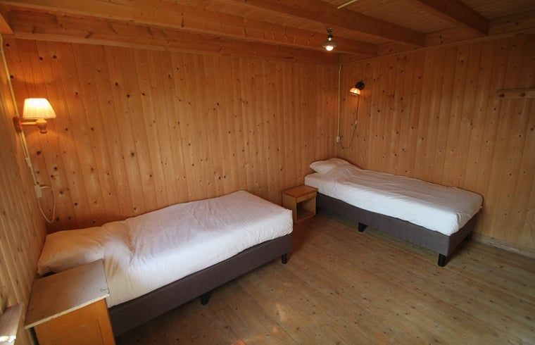 Ruime slaapkamer met houten interieur in Vakantiehuis in Lemele, Archem, Overijssel.