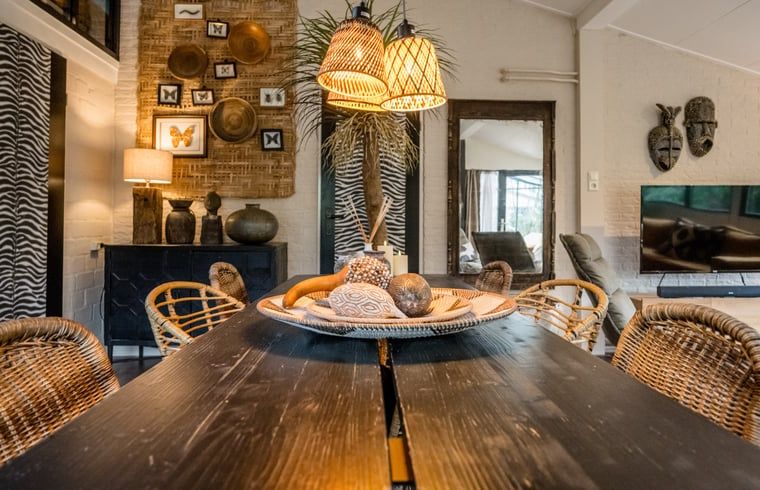 Esstisch im Ferienhaus in Rheezerveen, Vechtstreek, Overijssel mit dekorativen Accessoires und warmer Beleuchtung.