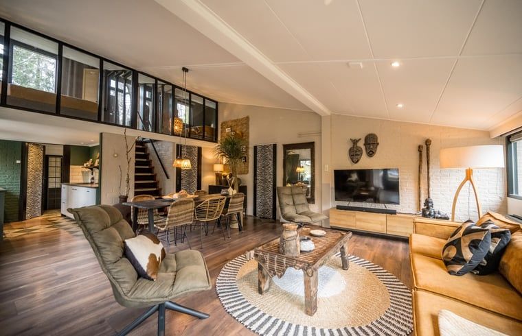 Modernes Wohnzimmer im Ferienhaus in Rheezerveen, Vechtstreek, Overijssel mit bequemen Sitzgelegenheiten und grossen Fenstern.