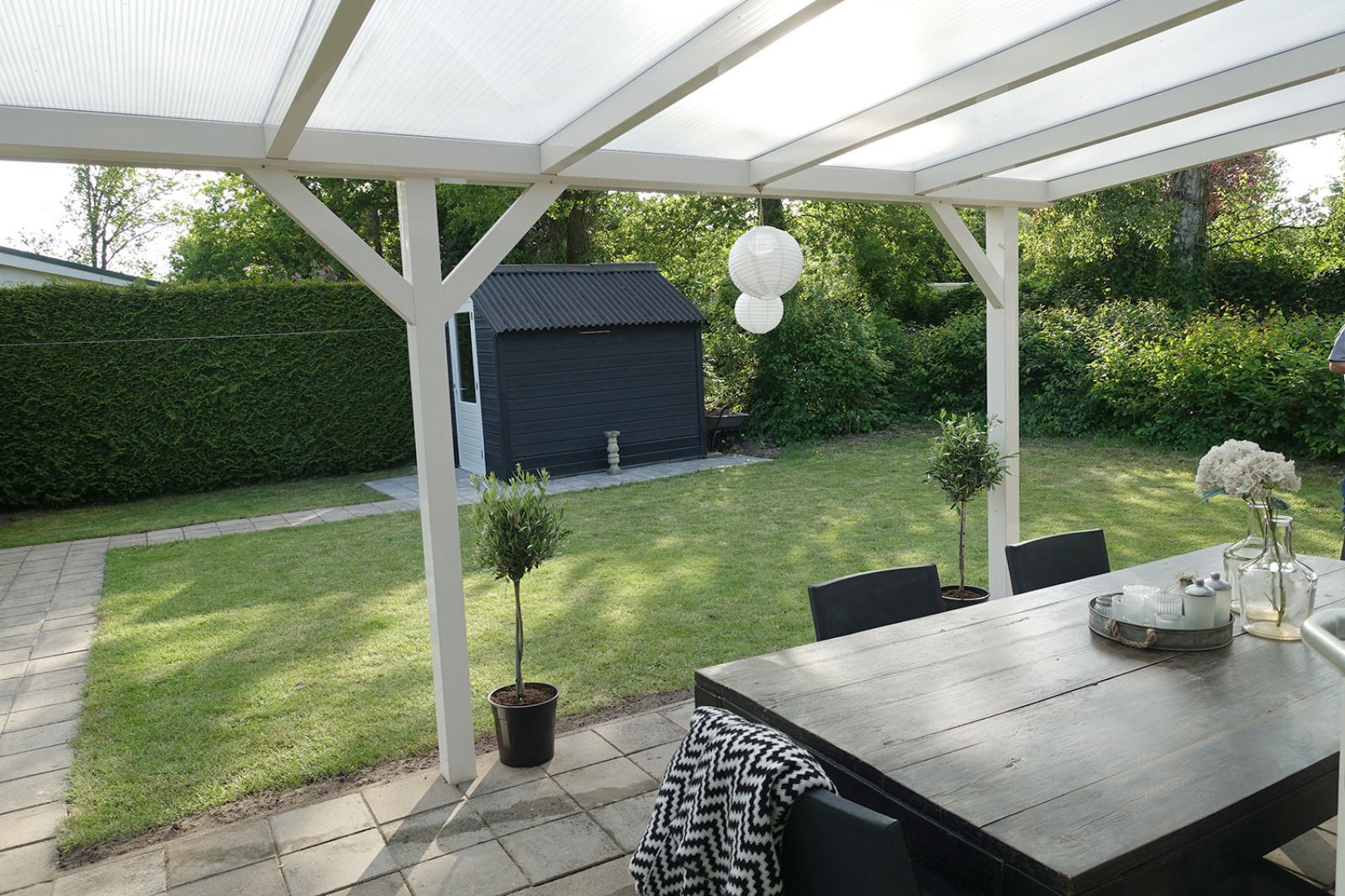 Rustikaler Garten des Ferienhauses OV649 in Rheezerveen, Vechtstreek, Overijssel, mit gruener Hecke und Weg zur Entspannung in der Natur.