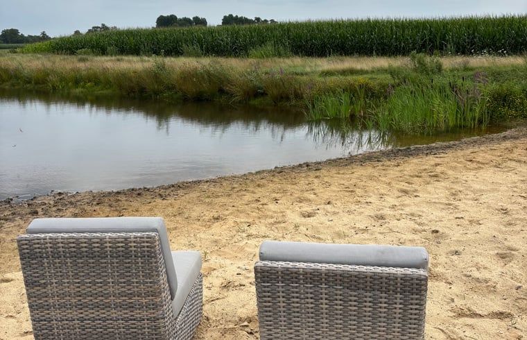 Sandstrand am Ferienhaus in Giethmen, Region Vecht, mit bequemen Stuehlen und Blick aufs Wasser in Overijssel.