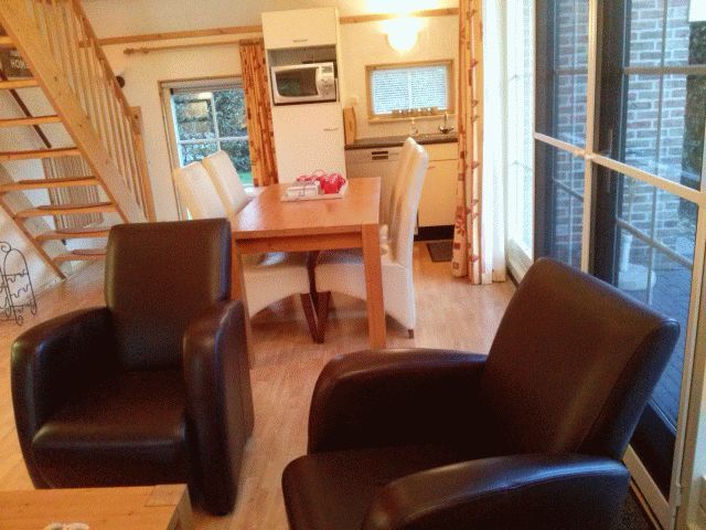 Gezellige woonkamer van vakantiehuis AA-Reestryck in IJhorst, Overijssel, met comfortabele stoelen en eetruimte.