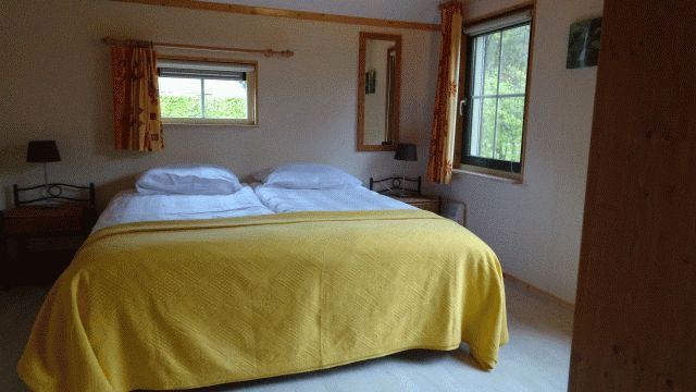 Gezellige slaapkamer in vakantiehuis AA-Reestryck, IJhorst, Overijssel, met comfortabel tweepersoonsbed en uitzicht op de groene omgeving.