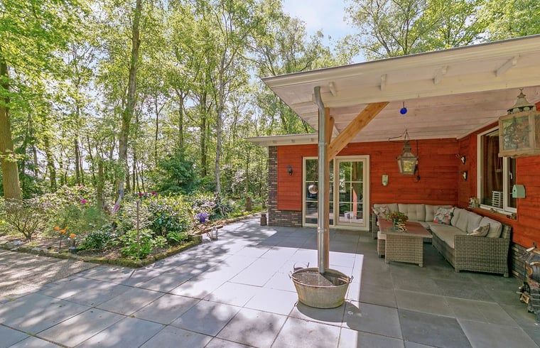 Comfortabele zithoek op het terras van Vakantiehuis in Bergentheim, omgeven door bomen in de Vechtstreek, Overijssel.