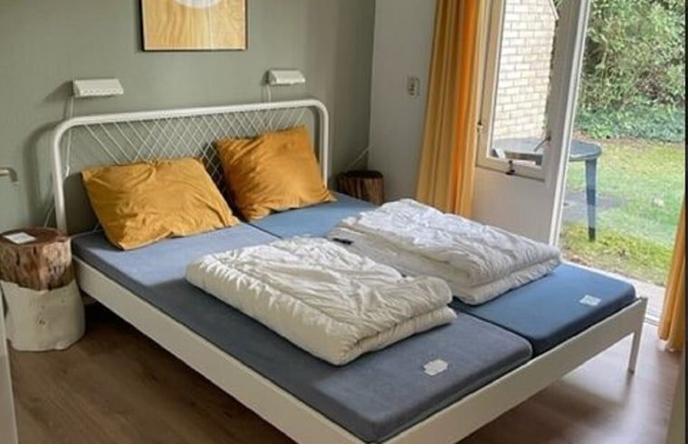 Comfortabele slaapkamer met tweepersoonsbed in Huisje in Lemele, Overijssel met toegang tot de tuin.