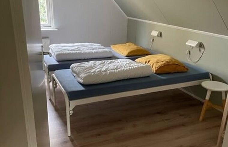 Gezellige slaapkamer in Huisje in Lemele, Overijssel met twee eenpersoonsbedden en houten vloer.