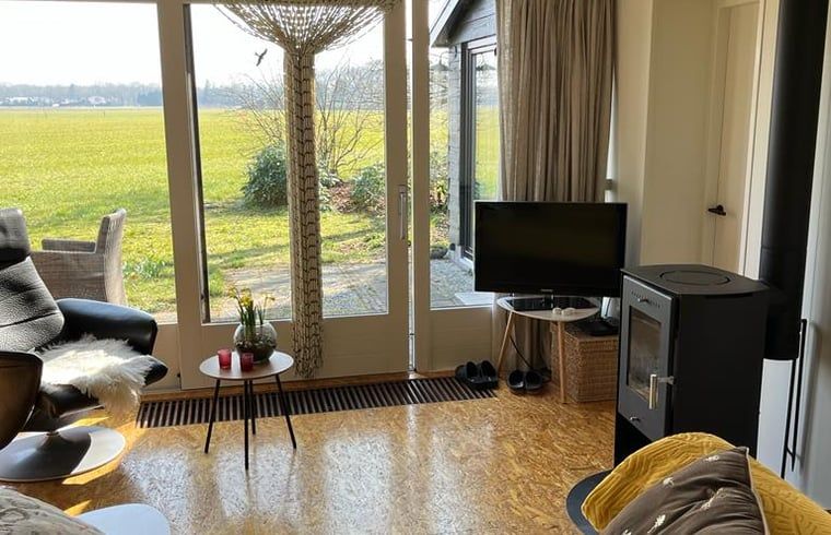 Uitzicht vanuit de woonkamer van Vakantiehuisje in Stegeren op de groene velden van Overijssel.