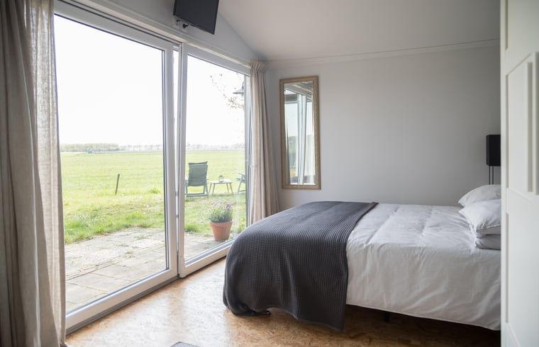 Slaapkamer met uitzicht op de velden in Vakantiehuisje in Stegeren, Overijssel.
