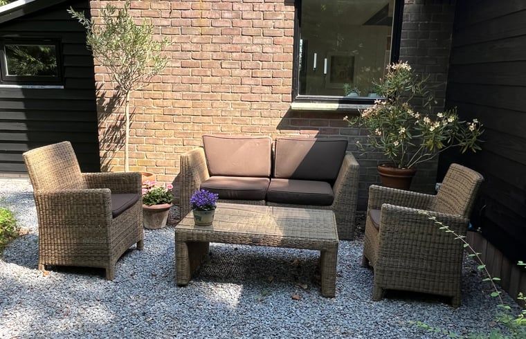 Knusse zithoek buiten bij Vakantiehuisje in Stegeren, perfect voor een zomerse dag in Overijssel.