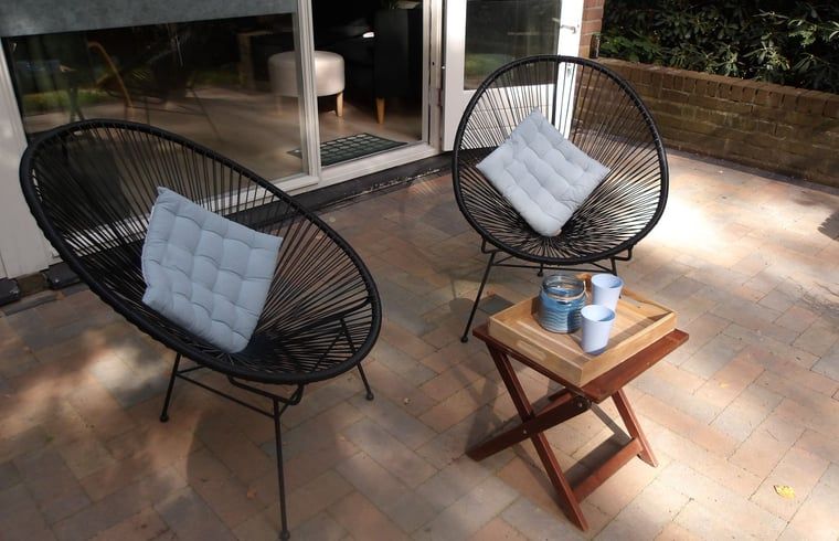 Geniessen Sie die Terrasse des Ferienhauses in Stegeren, Vechtstreek, Overijssel, mit bequemen Stuehlen und einem gemuetlichen Tisch.