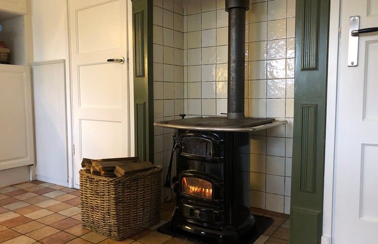 Gezellige houtkachel in Vakantiehuisje in Den Velde, Vechtstreek, Overijssel, biedt warme sfeer in de knusse binnenruimte van het vakantiehuis.