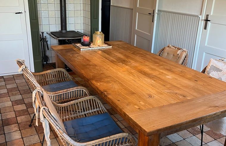 Gezellige eetkamer in Vakantiehuisje in Den Velde, Overijssel, met rustieke houten tafel en sfeervolle inrichting in de Vechtstreek.