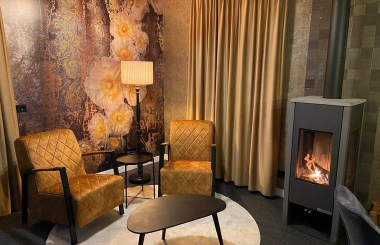 Comfortable lounge area with fireplace in cottage in Kloosterhaar, Vechtstreek, Overijssel.