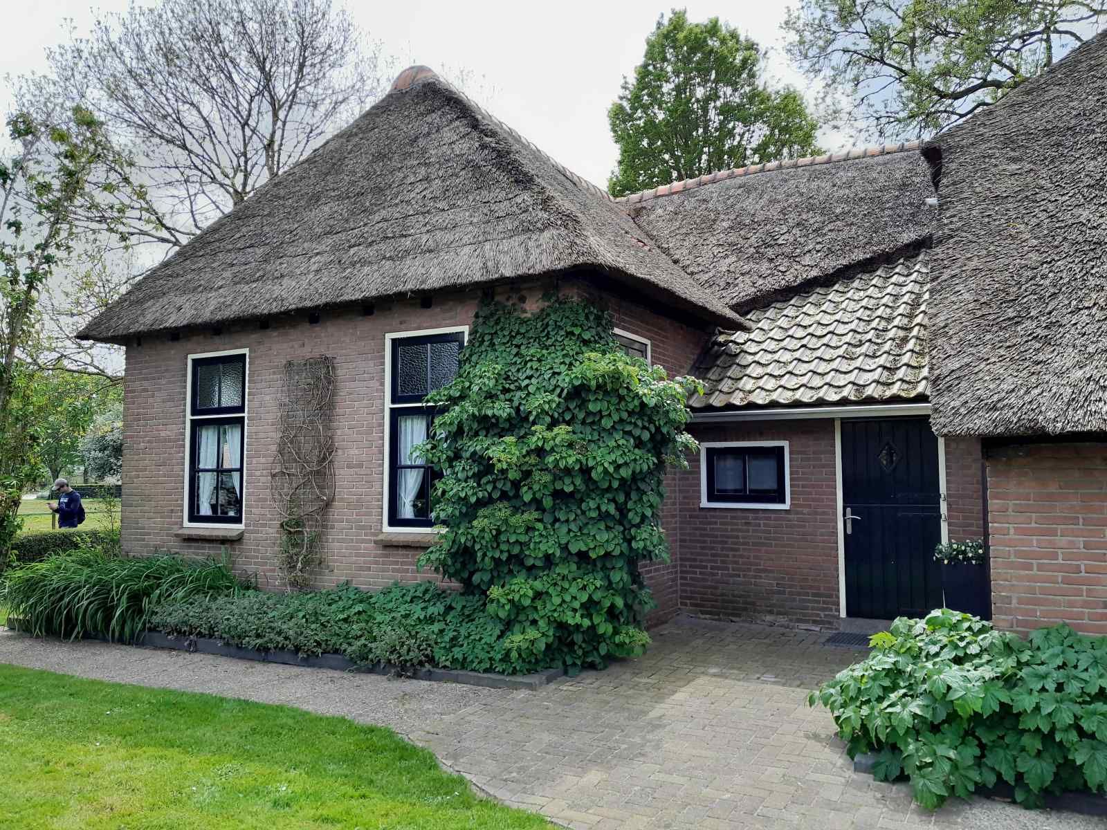 Traditional vacation home OV602 in Giethoorn with thatched roof and green surroundings.
