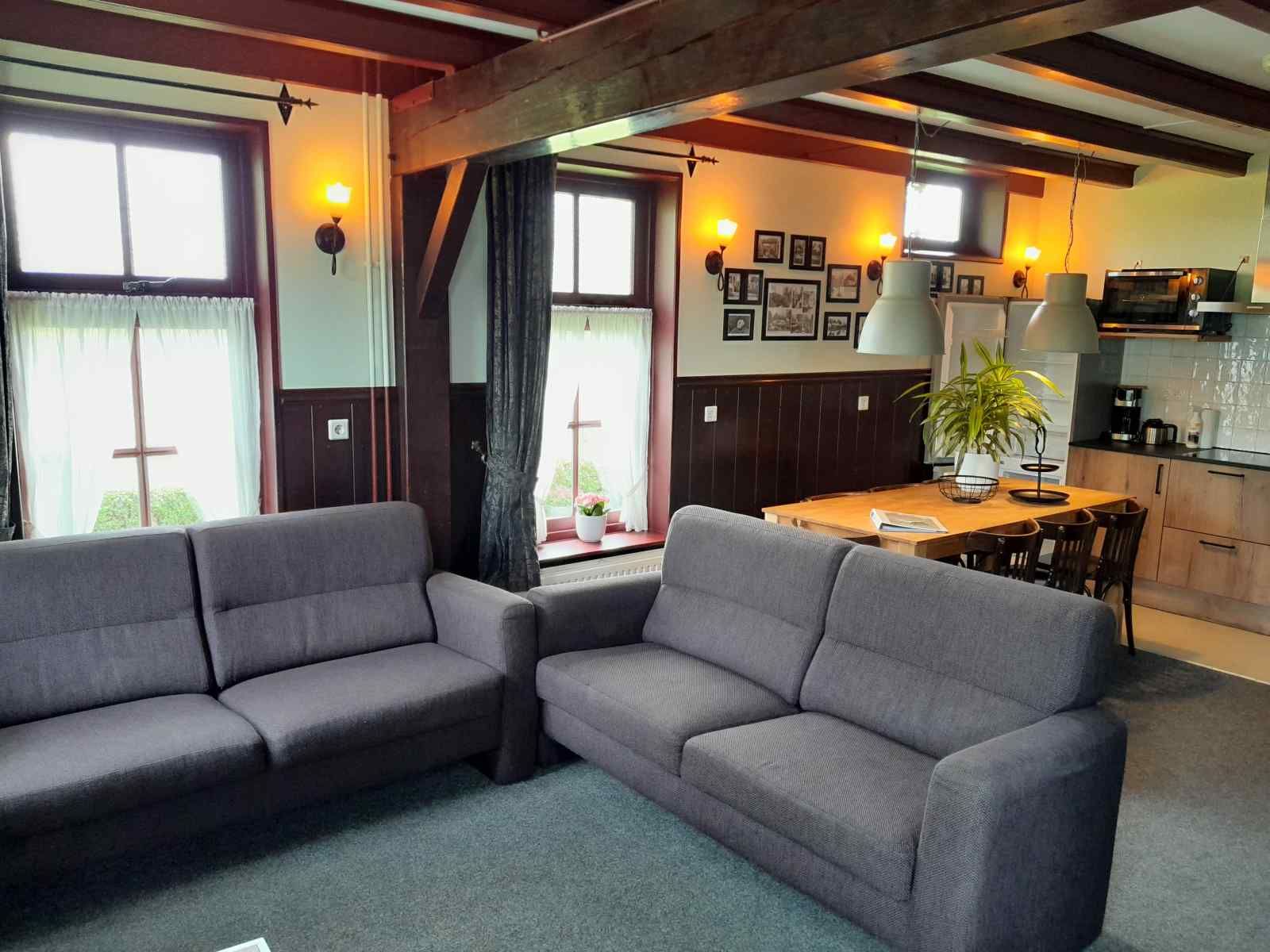 Comfortable living room in vacation home OV602 in Giethoorn with sofas and wooden beams.