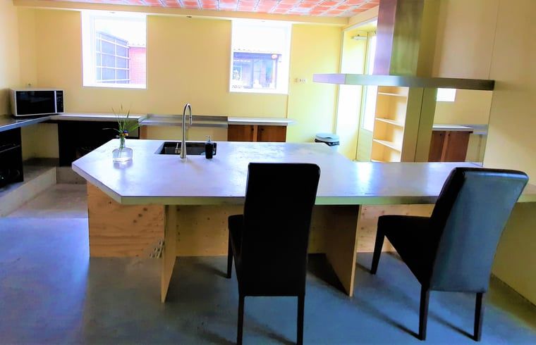 Modern kitchen of Huisje in Giethoorn, vacation home in picturesque Giethoorn, Overijssel, with spacious dining table and stylish furnishings.