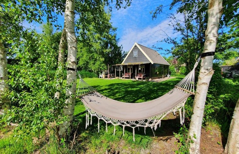 Geniessen Sie die Haengematte im Ferienhaus in Giethoorn, einem idyllischen Ferienhaus in Nordwest Overijssel, umgeben von ueppiger Natur.