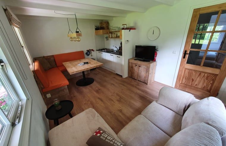 Innenbereich des Ferienhauses in Giethoorn, ein gemuetliches Ferienhaus in Overijssel, mit bequemer Sitz- und Essecke.