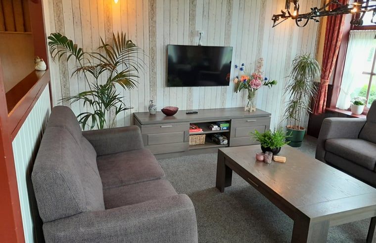 Moderne woonkamer met flatscreen-tv in Vakantiehuisje in Giethoorn, Noordwest Overijssel, Overijssel.