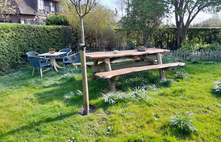 Tuin met picknicktafel en zitgedeelte bij Vakantiehuisje in Giethoorn, Noordwest Overijssel, Overijssel.