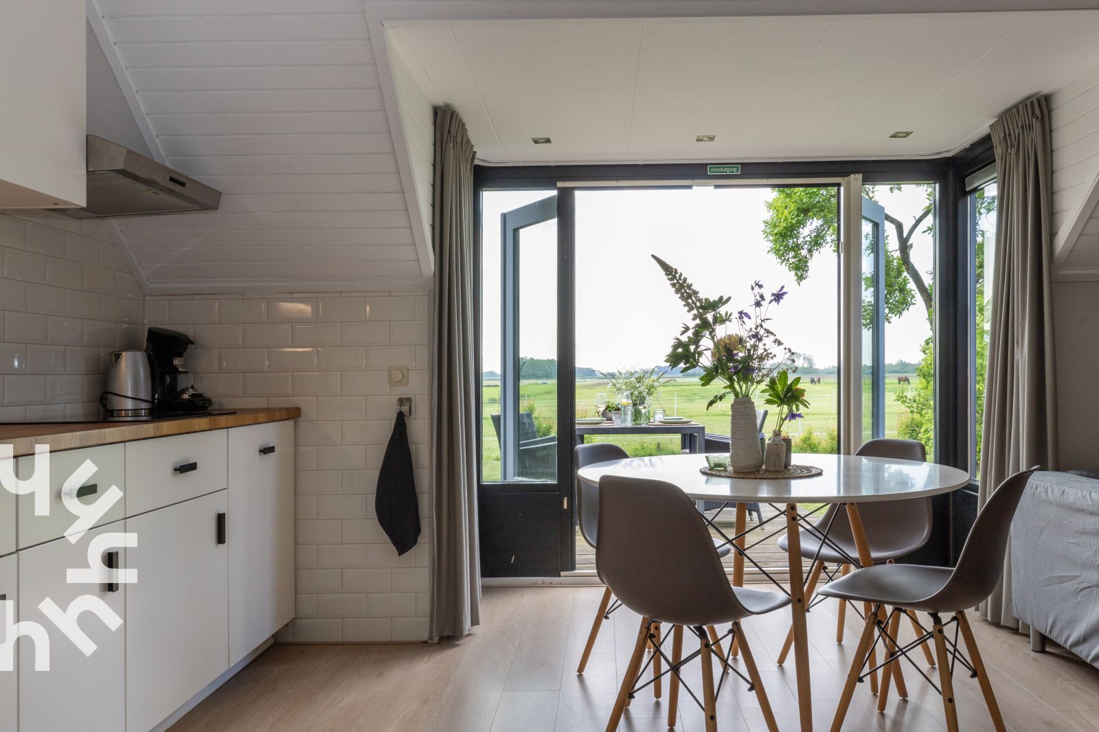 Hinterhof des Ferienhauses OV591 in Wanneperveen, Overijssel mit Terrasse und Gruenflaeche.